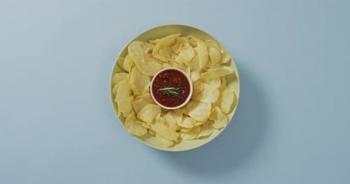 Primer plano de las patatas fritas en un bol con salsa sobre una superficie azul