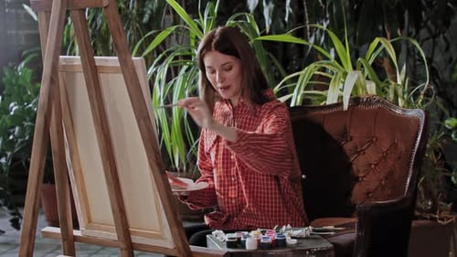 Artist in a Workshop Young Pretty Smiling Woman Drawing a Painting with Colors