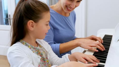 Girl Learning Piano with Woman Inside Bright Home
