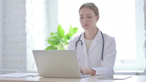 Lady Doctor Looking at Camera While Sitting in Clinic
