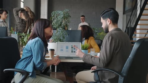 Smartphone Application Designers Man and Woman Talking Looking at Laptop Screen in Office