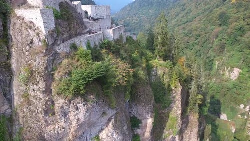 Castle and Watchtower on the Edge of the Cliff in Dense Forest