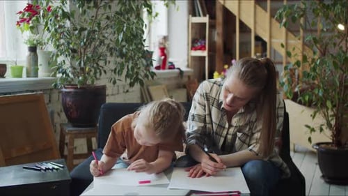 Young Woman and Child Drawing Together Indoors