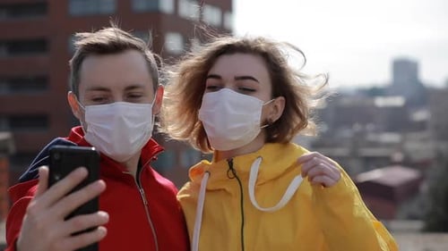 Couple Make Selfie in Surgical Masks on the City Roof