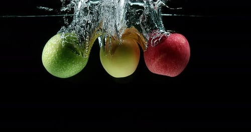 Apples, malus domestica, Fruits entering Water against Black Background, Slow Motion 4K