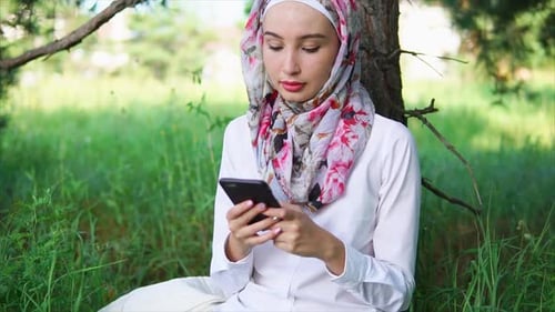 Woman Uses Phone in Meadow