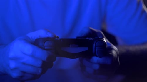 Hands Use Game Controller in Blue Light