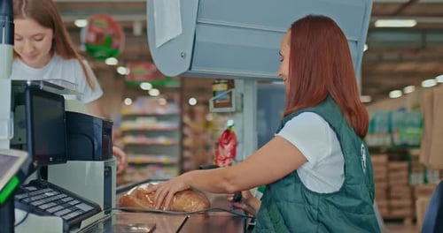 Women Working at Supermarket Checkout Scanning Groceries