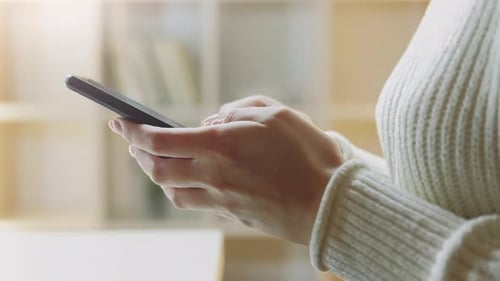 Woman's Hands Typing on Mobile Phone Indoors