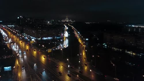 Une vue aérienne de nuit d'une route très fréquentée contre le paysage urbain sans fin