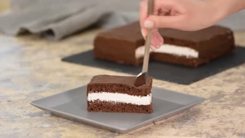 Woman Cuts into Chocolate Cream Cake Slice