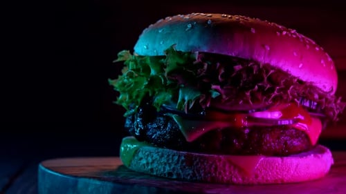 Delicious Burger with Neon Lighting on Wood