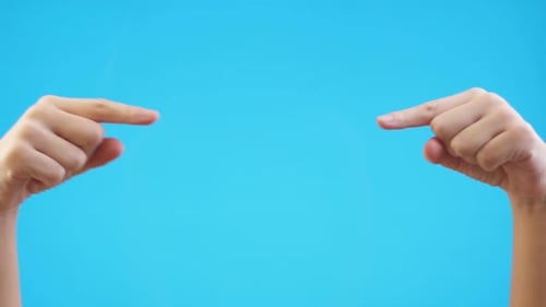 Woman Hands Pointing on Copyspace Isolated Over Blue Background in Studio. Copy Space for