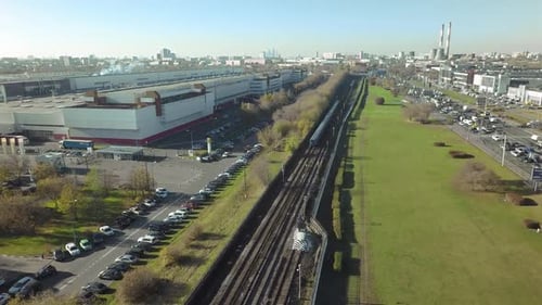An Aerial View of an Industrial Urban Area with Railways, Parking Lots and Busy Traffic