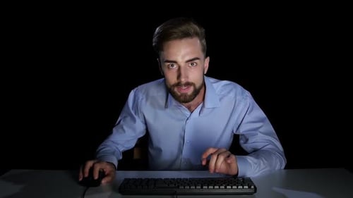 Mann mit einem aufgeregten Umgeschriebenen im Online-Chat. Dunkles Studio