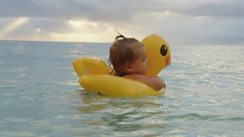 Retrato de bebê adorável flutuando em um pato inflável no Oceano Índico