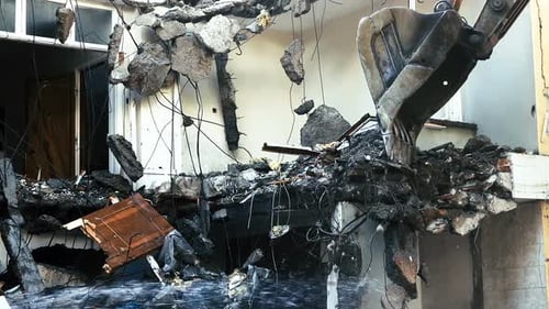 Excavator Demolishes Building Ruins with Water Spray