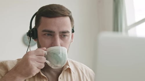 Young Man Working Remotely with Headset