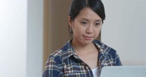Woman Works on Laptop Computer Indoors