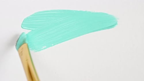 Pinceladas abstractas de pintura turquesa aplicadas aisladas sobre un fondo blanco
