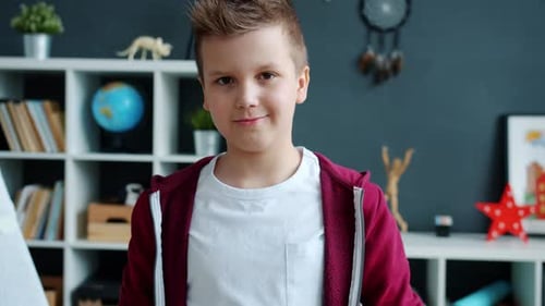 Smiling Boy Poses Indoors with Bookshelf