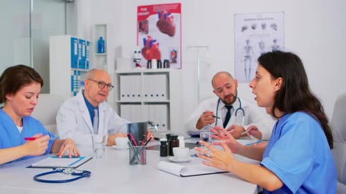 Team of Physicians Talking About Symptoms of Disease in Hospital Boardroom