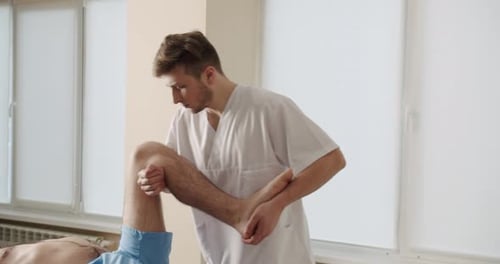 Therapist Manipulates Young Adult's Leg in Medical Office