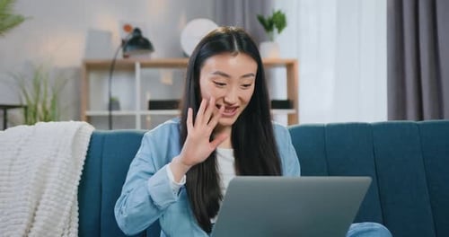 Woman Using Laptop for Video Call on Couch