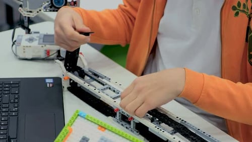 Junge in der Robotik-Schule macht Roboter