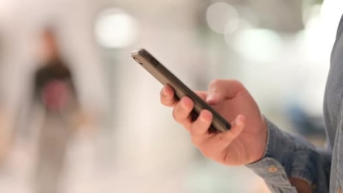 Hand Using a Mobile Phone in an Urban Setting