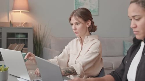 Deux femmes interraciales travaillant sur des ordinateurs portables au bureau à domicile