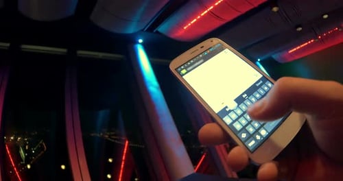 Hand Texting on Smart Phone in City Building