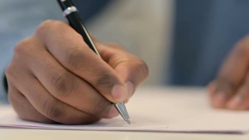Nahaufnahme eines afrikanischen Mannes, der auf Papier schreibt