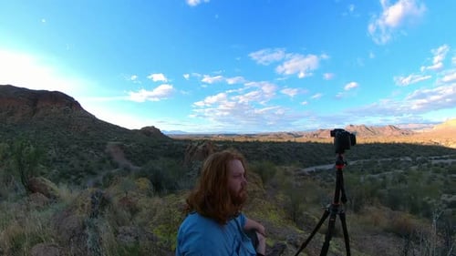 Man with Camera Contemplates Mountain Desert Landscape