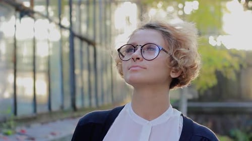 Woman Looks Upward Outdoors on Sunny Day