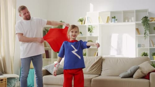 Father Drapes Red Cape on Superhero Daughter