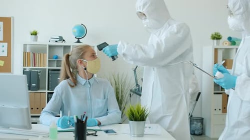 People in Protective Costumes Checking Body Temperature in Office with No-touch Thermometer