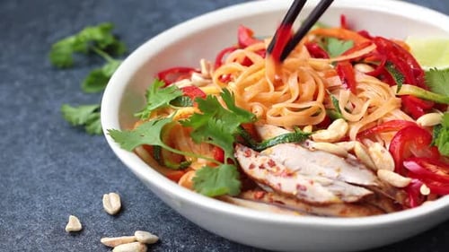 Noodle Salad with Chicken Being Served with Chopsticks