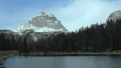 Grüner Wald rund um den Bergsee in den Dolomiten, Wolkenlandschaft, Zeitraffer