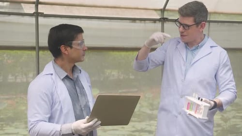 Two scientist man research with chemical and laptop computer plant about agriculture in the farm.