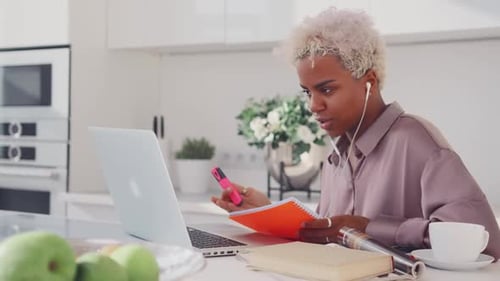 Jovem mulher afro-americana lendo conspecto para interlocutor em laptop
