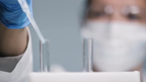 Woman Experimenting in Lab with Pipette