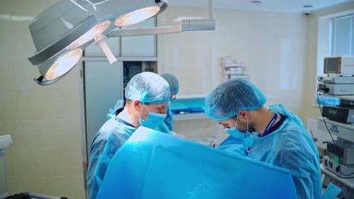 Surgical Team Working In Operating. View of surgeons in the operating room with patient