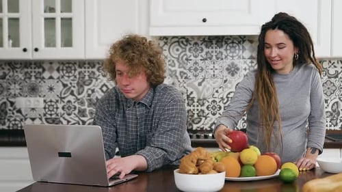 Couple Using Laptop Together in Bright Kitchen