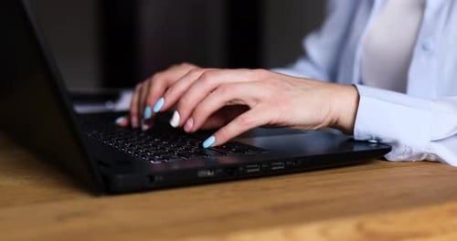 Woman Typing on Laptop Keyboard at Desk