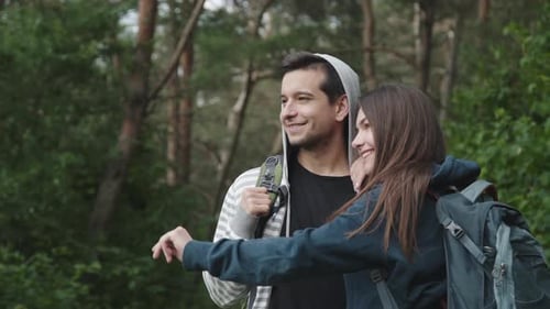Lovely Couple on the Walk in Forest Having Fun and Looking Into the Distance
