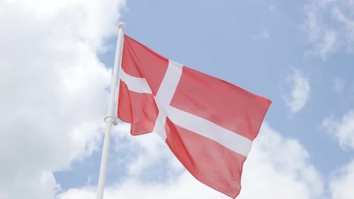 National flag of Denmark in front of cloudy sky waving 4K 2160p 30fps UHD footage - Red Danish flag