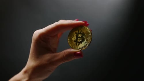 Hand Holding a Golden Bitcoin, Close Up