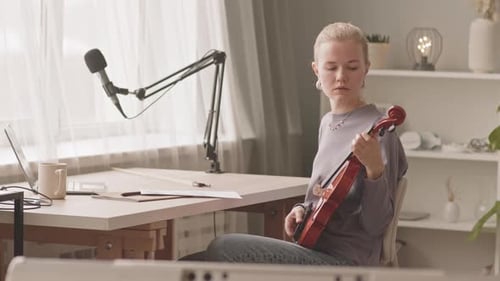 Woman Practicing Violin in Home Studio