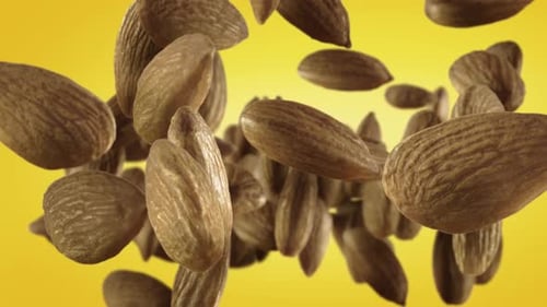 Almonds Floating Against a Yellow Background